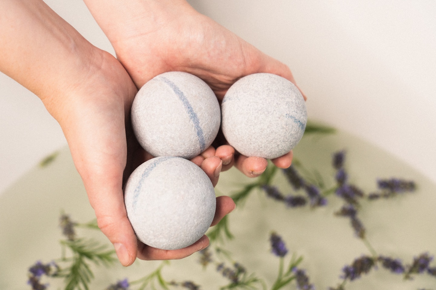 Three Eir Health CBD bath bombs slowly dissolve in a warm bath, their effervescence creating a soothing and relaxing ambiance. Each bath bomb introduces a different hue to the water, painting a serene, color-infused picture of chill time. This image perfectly encapsulates the multi-sensory relaxation experience offered by these innovative wellness products.